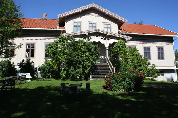 Kvinnemuseet med blomsterbed og sveitserstilveranda