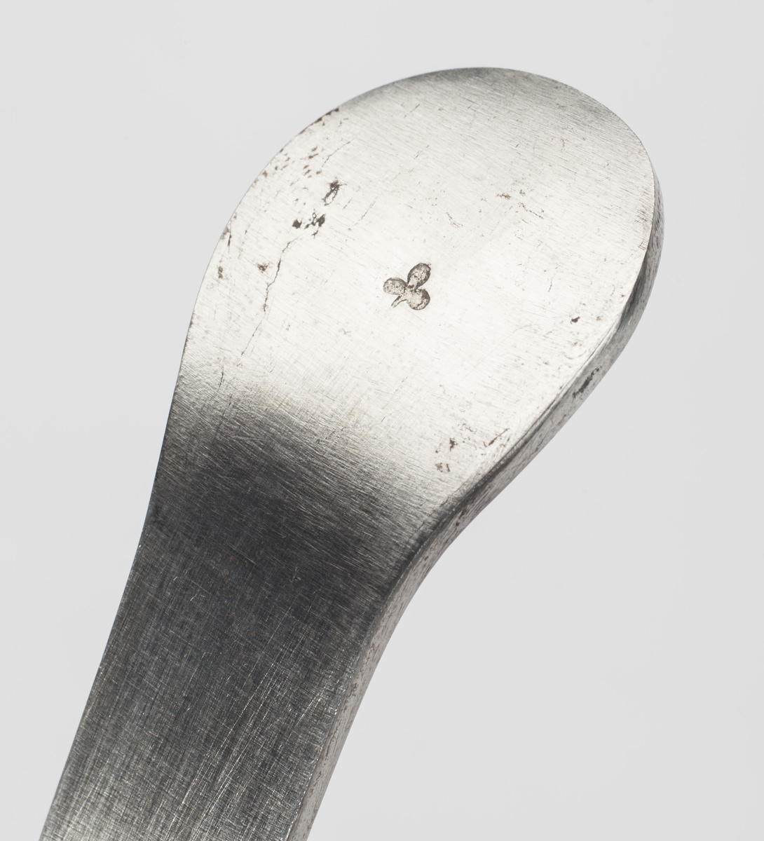Instrument med en flat ende og en krum ende med et spor. Sonden er bøyd for å passe til urinrørets krumning hos mannen.