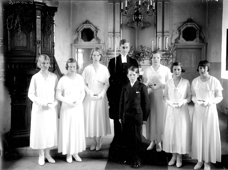 Konfirmander, 6 flickor, en pojke och en präst.
Interiör av Norrbyås kyrka.