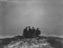 Skiløpere hviler seg på fjellet.