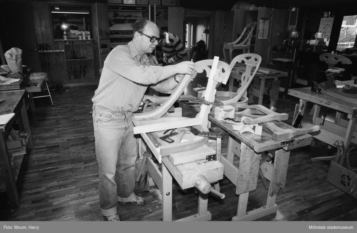 Kurs i lindomesnickeri i Sinntorpsskolans slöjdsal i Lindome, år 1983. En man som tillverkar göteborgsstolar.

För mer information om bilden se under tilläggsinformation.