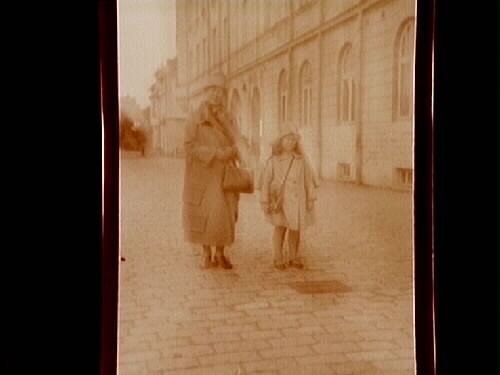 En kvinna och en flicka.
Gerda Thermaenius med dottern Barbro på väg till hennes första skoldag.
I bakgrunden "Stora huset", bostad och kontor för "Johan Thermaenius & Son AB".