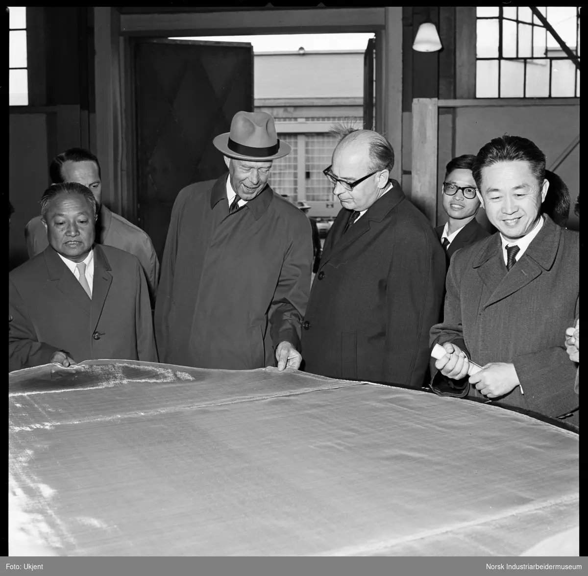 Kinesisk delegasjon besøker Eidanger Salpeterfabriker. Direktør Klingenberg viser platinanett.