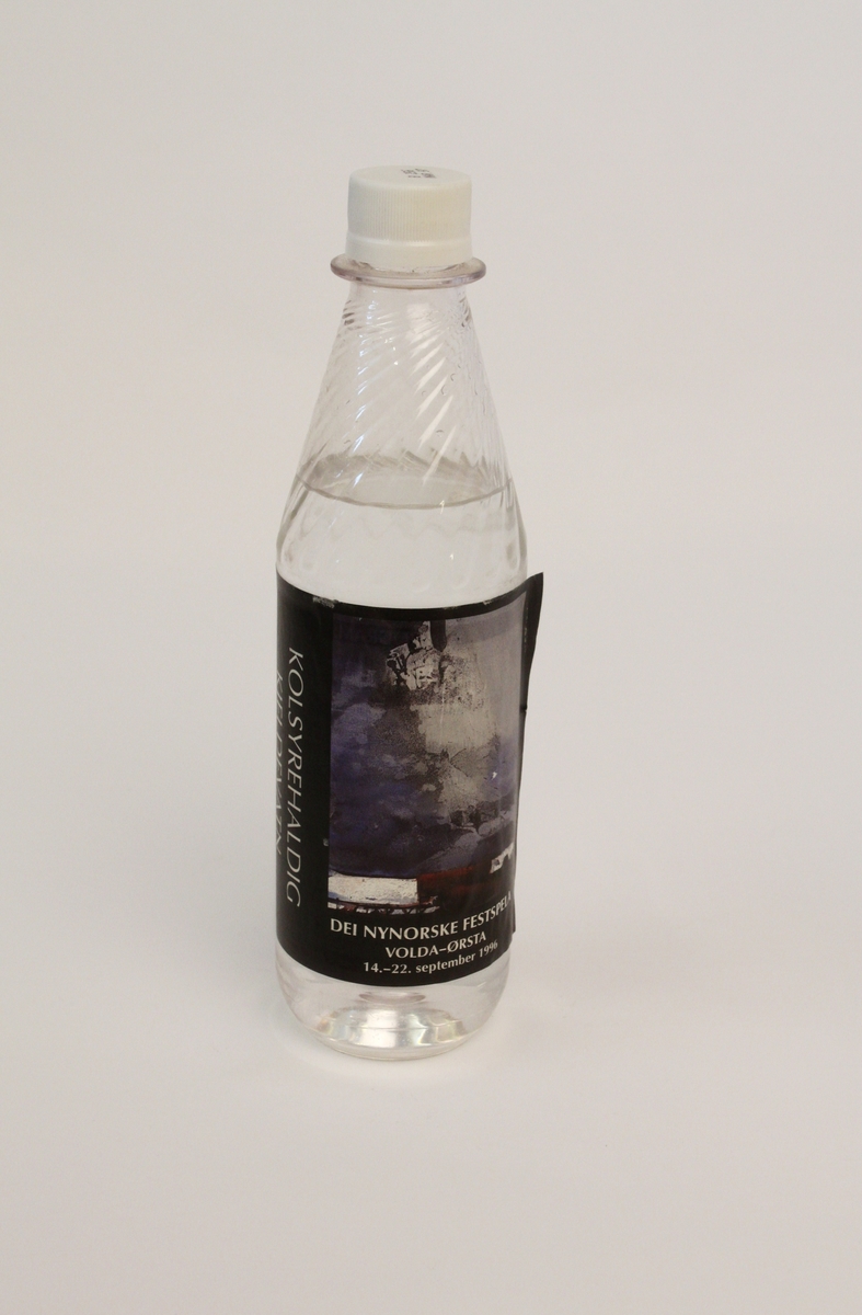 Plastflaske med skrukork til kolsyrehaldig vatn, brukt under Dei nynorske festspela 1996. Etikketten er pryda med det same motivet som er på festspelplakataten, nemleg kunstverket "Vind fra vest" av Ørnulf Opdahl.