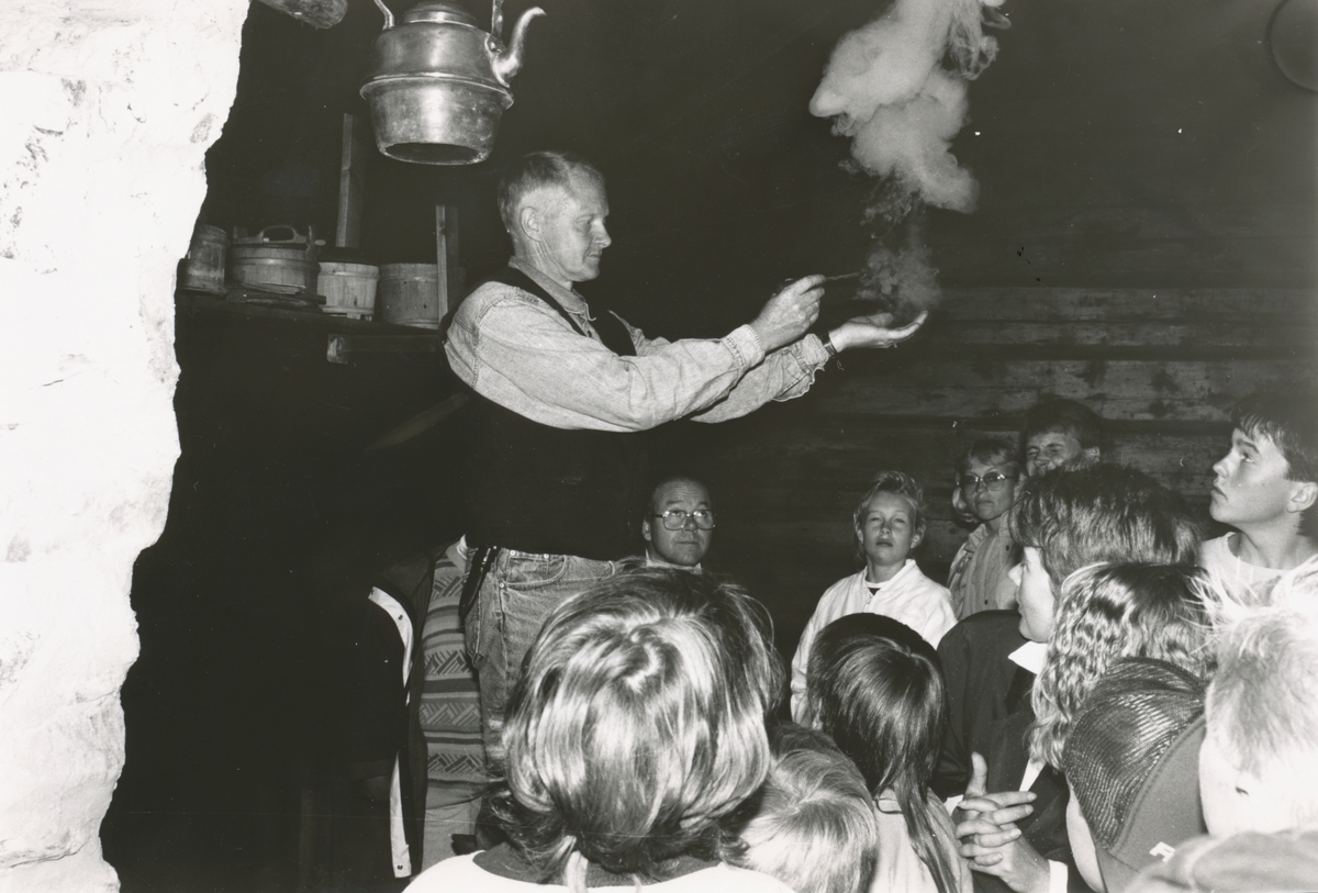 Olav Bekken prøver kruttet i handa foran publikum. Slik kunne en ta varsel om jakta. Fra Museumsdagen ved Sunnmøre Museum 1990.