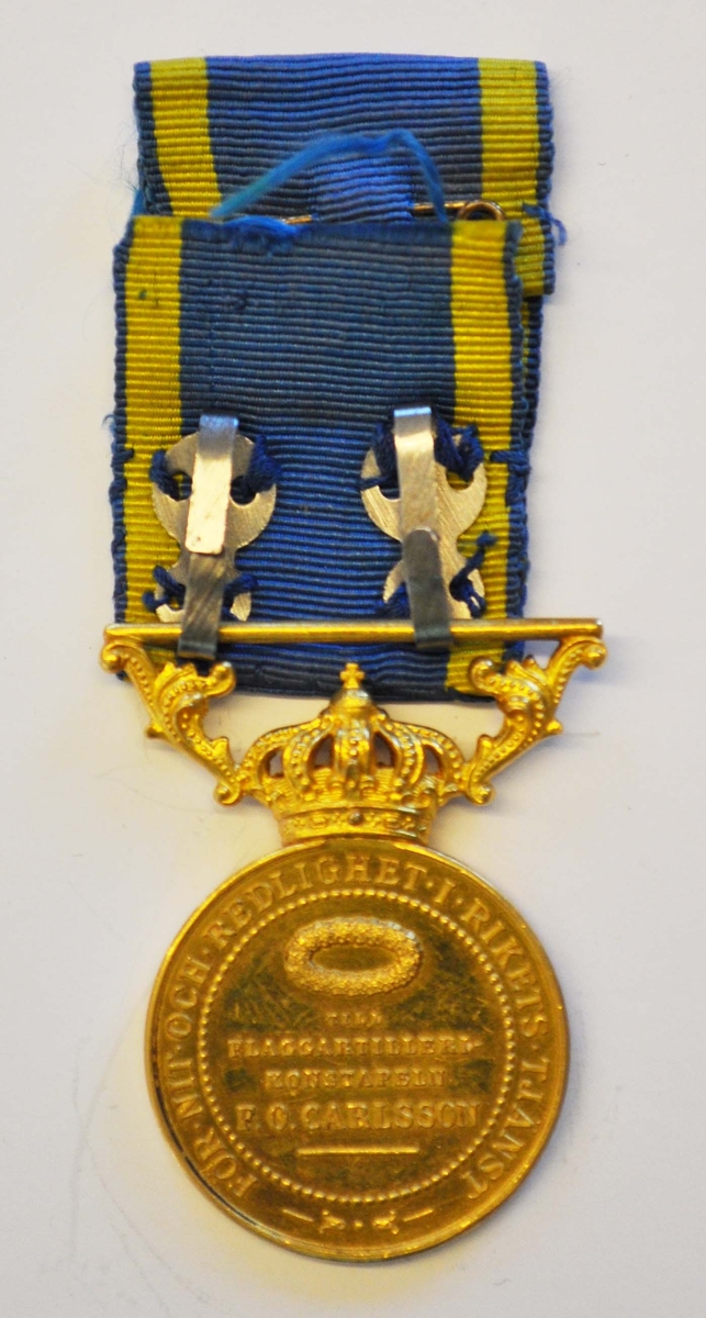 Medalj "För nit och redlighet i rikets tjänst" i blågult band, i sekundärt etui.