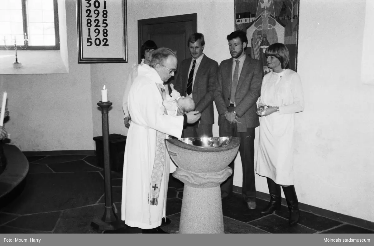 Kyrkoherde Gustaf Lindman förrättar ett dop i Kållereds kyrka, år 1984.

Fotografi taget av Harry Moum, HUM, Mölndals-Posten, vecka 8, år 1984.