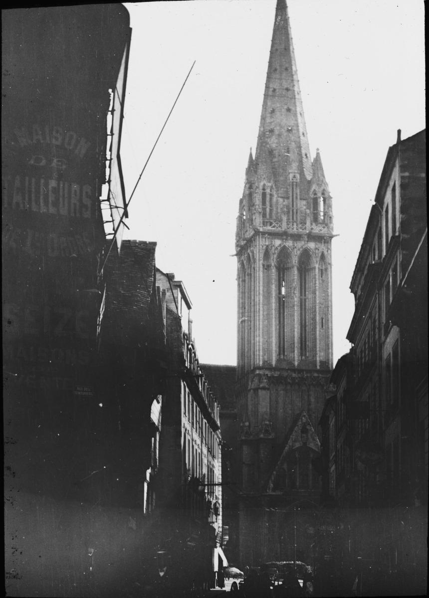 Skioptikonbild med motiv från Caen med catedralen Saint Pierre i bakgrunden. (Staden förstördes delvis i kriget 1944).
Bilden har förvarats i kartong märkt: Resan 1908 IX. Lisieux 2. Caen 6. Text på bild: "Caen. Cathe'd. Saint Pierre".