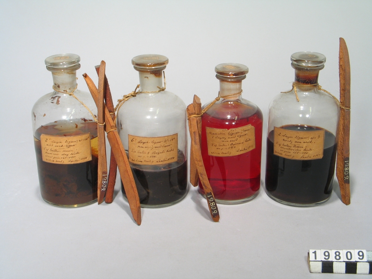 En samling prover från en serieundersökning över garvämnens av olika sammansättning på olika hudar vid dessas förvandling till läder. Provarna bestå av bark, garvämnesextrakt i flaskor av glas och garvade hudar med etiketter, signerade Landin 1884.