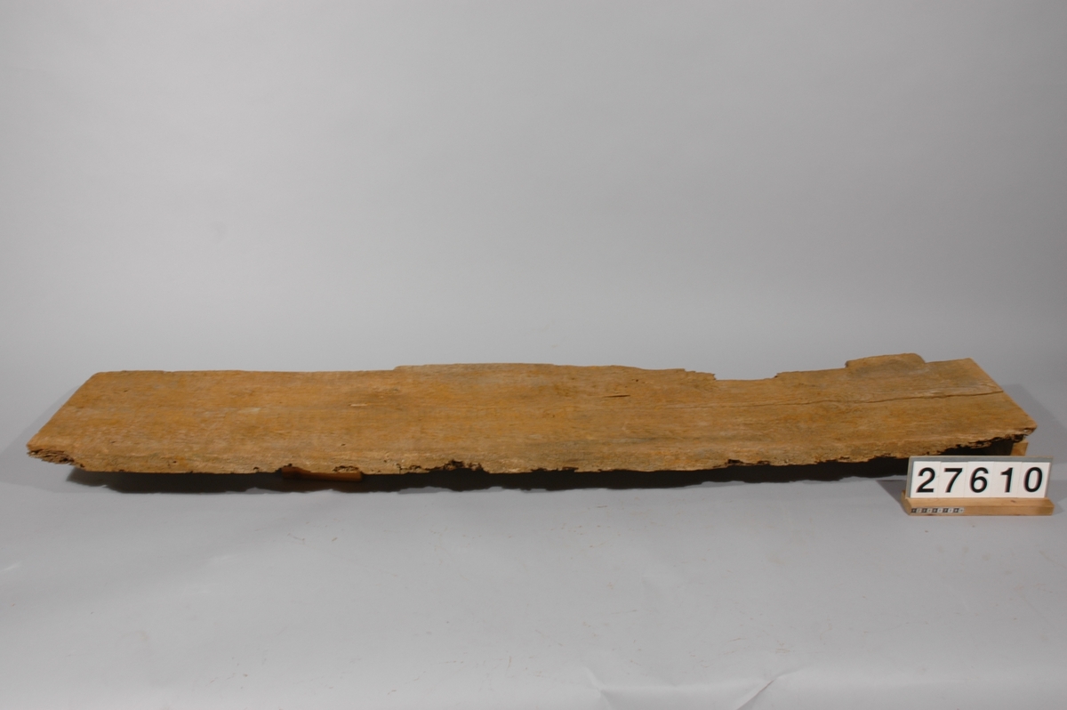 Planka av furu, 2 x 16 tum, sågad i en vattenhjulsdriven sågkvarn. Fyra av skeppsmask e.d. starkt angripna bitar, avsågade från plankan ingår under detta inv.-nr.