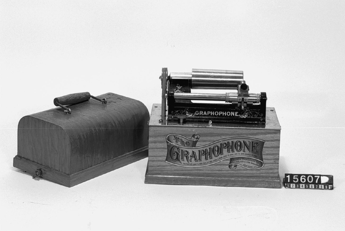 Fonograf för vaxrullar enligt Edison, dekorerad med blomrankor, med veven separat. Ljuddosan saknar membran och tratt saknas.