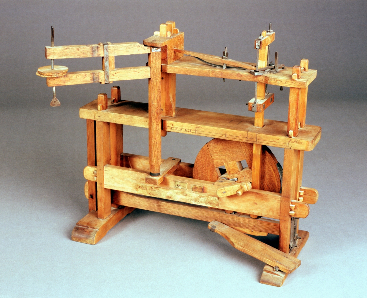 Modell av maskin för sågning av bottnar till askar. Text på föremålet: "N:o 317. Modell på Invention at såga Bottnar till Askar. Af fram .... Directeurn Norberg, XIV.B.18. B-d-(?) N:o 143."