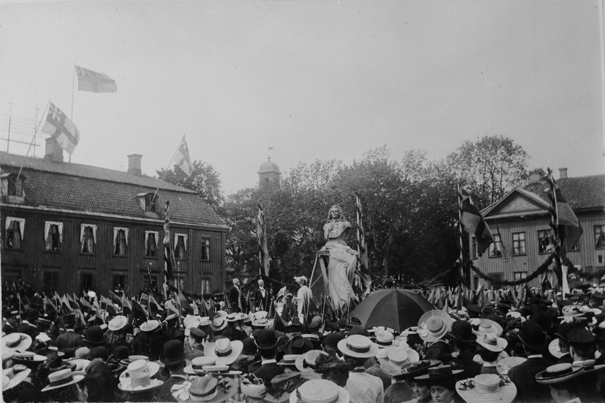 Stor samling människor på torget i Alingsås vid invigning av staty föreställande Jonas Alströmer av konstnären Aron Sandberg. Statyn uppfördes och invigdes den 2 juni 1905. Bild från tidskriften Hemmets bildmaterial.