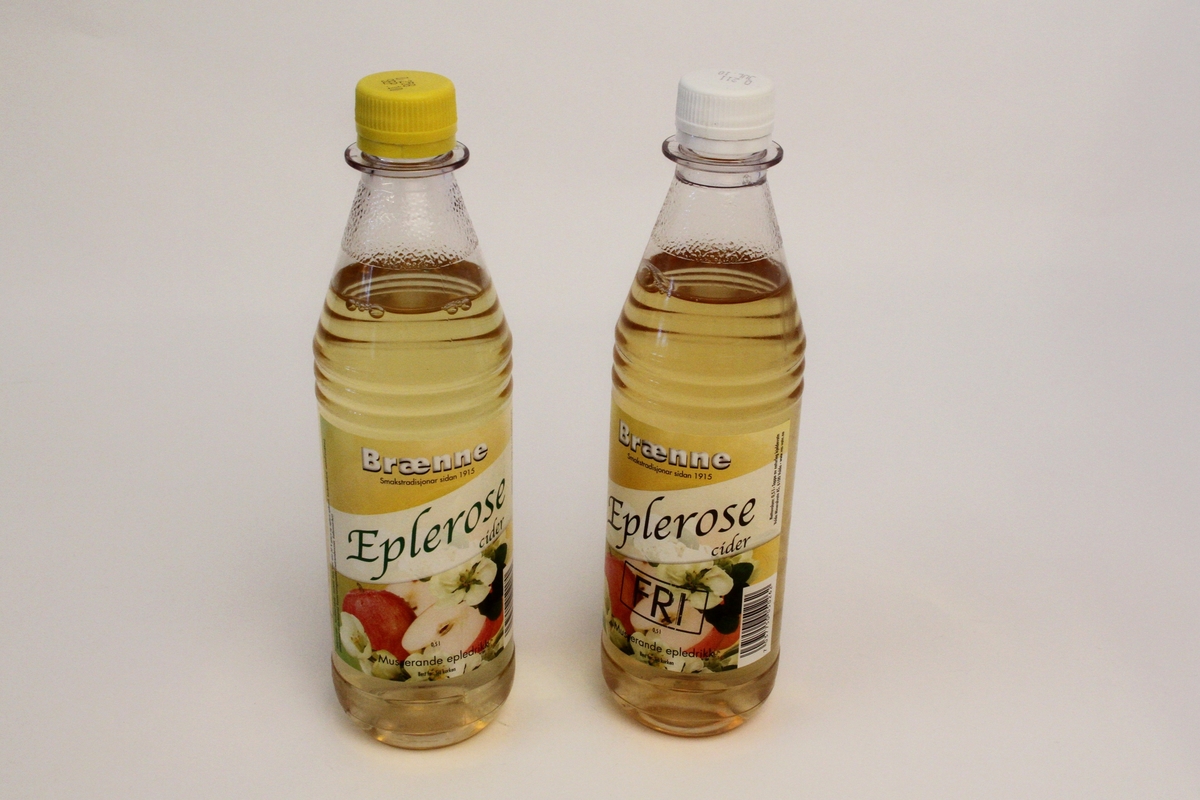 Brusflaskene har begge ein etikett med bilete av epler og epleroser på gul bakgrunn. Produktnamn på skrå over etiketten. Alle trykt skrift i svart.