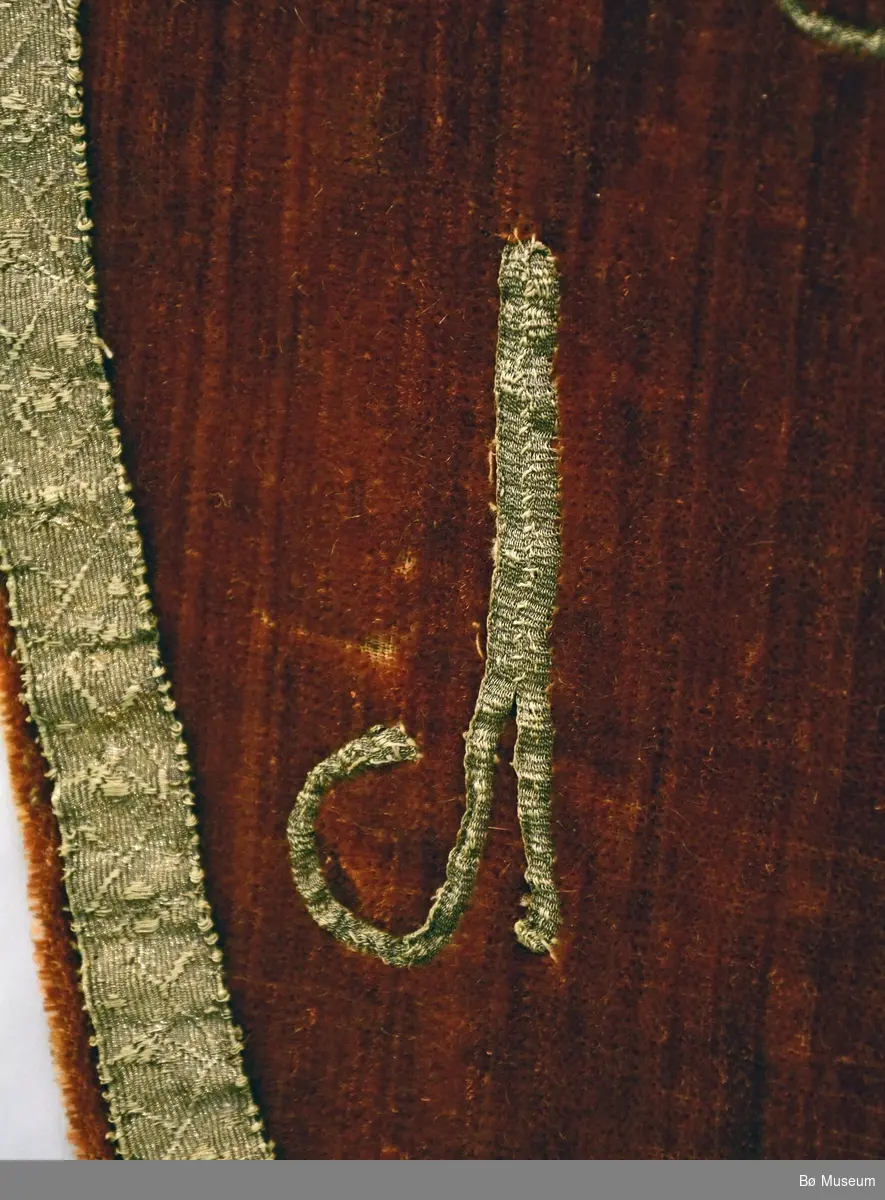 Kors i silke og sølvband, sølvband langs kant.
