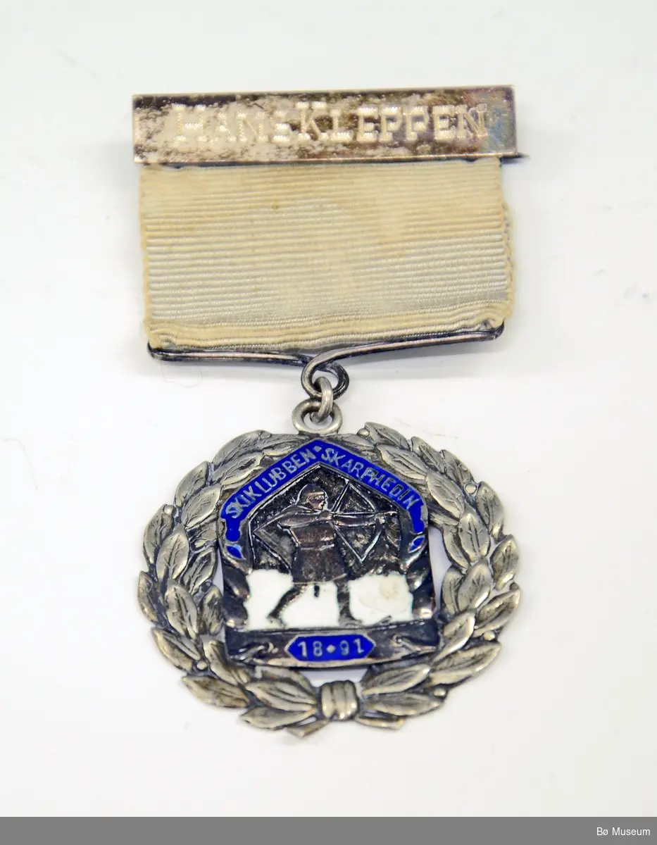 Medalje med innskrift:
HALVOR KLEPPEN
og Skiklubben Skarphedins (1891) merke/logo.
Båndet opprinnelig blått - falmet til gulhvitt.
