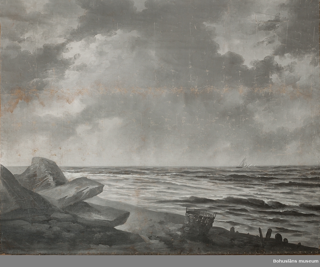 Fond av tunn, tätvävd bomullsväv med måleri i gråa nyanser.
Sjömotiv föreställande utsikt över hav och himmel från en strand med större stenar och en korg, vattenyta och horisont, fyra segelbåtar med spirsegel mot en molnig himmel.
Upphängning med en gråmålad trästång fästad i övre kortändan.
På baksidans nedre del antecknat för hand: "See am Rand", ung. "Vid strandkanten".
Samhör med UM71.22.005:A Fotstöd på hjul, 
Blankettens illustration avbildar en kvinna porträtterad framför bakgrunden.