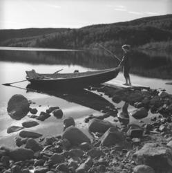 Turid Karikoski på tur ombord i en elvebåt med en fiskestang