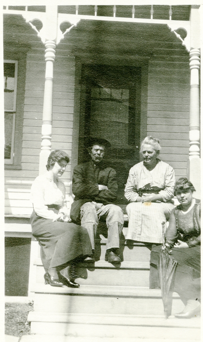 3 kvinner og en mann sittende i ei trapp. Bildet er tatt i Amerika. Fra venstre:Gurine og Per (Peder) Islandsmoen, Mable og Sara.