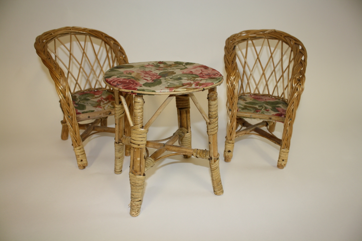 To stoler og et bord

Setet på de stolene, samt bordplaten har et trekk i blomstrete (rose) trekk.