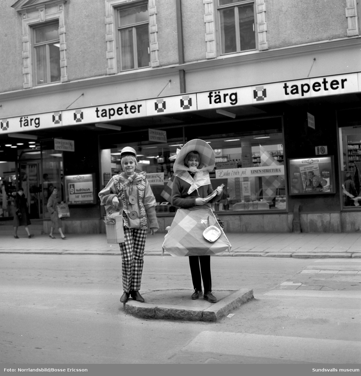 Strömbergs färghandel gör reklam för säsongens vaxdukar med hjälp av två unga kvinnor utstyrda i plagg tillverkade av just vaxduk.