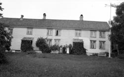 To kvinner og to menn utenfor et lån. Fra Nordmøre museums f