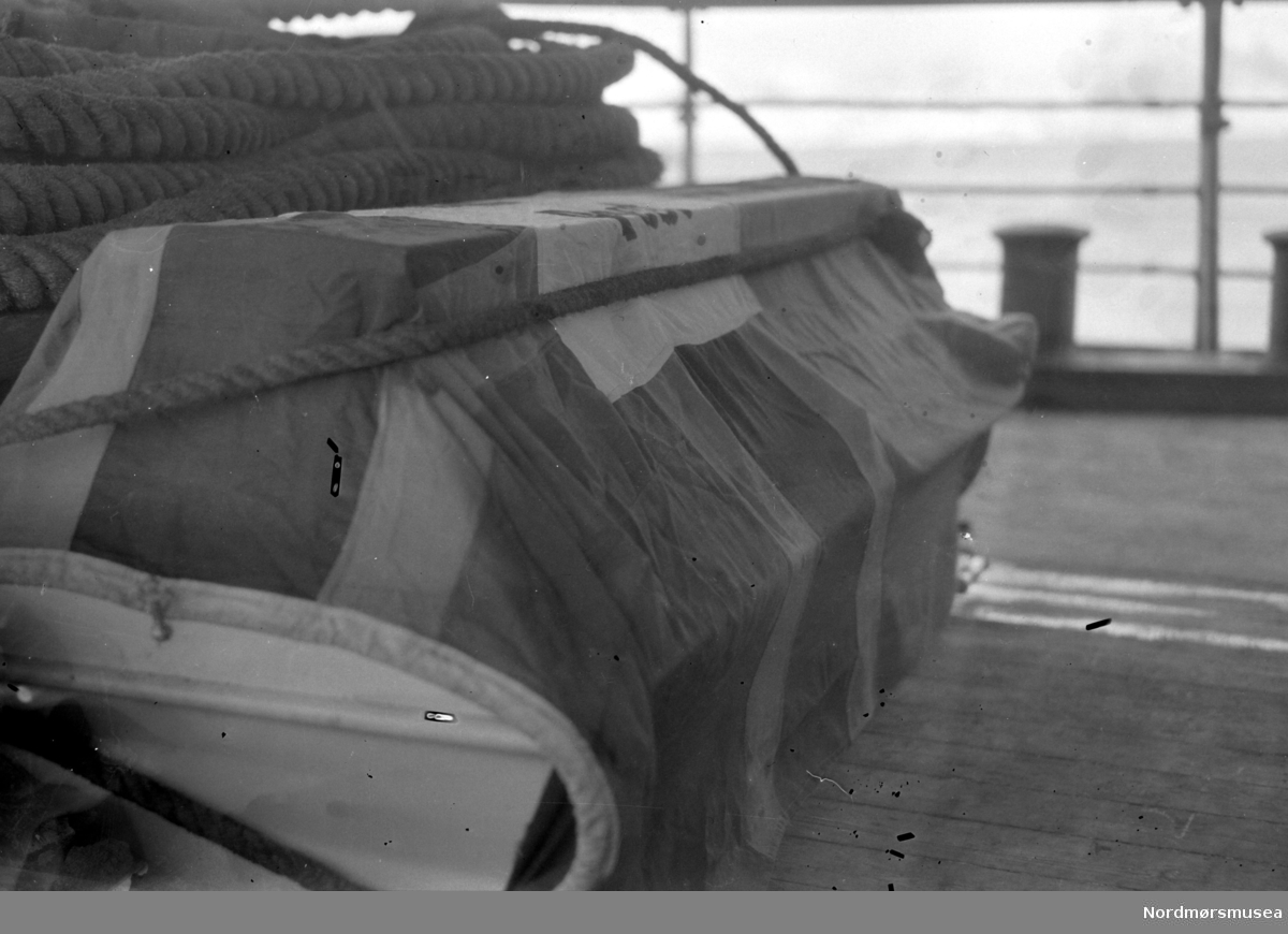 Likkiste dekket med flagg ombord i en båt. Fra Nordmøre museums fotosamlinger. EFR2015