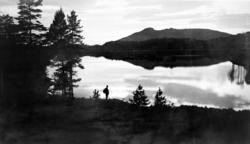 Foto fra en turgåer med sekk nede ved en innsjø usikkert hvo