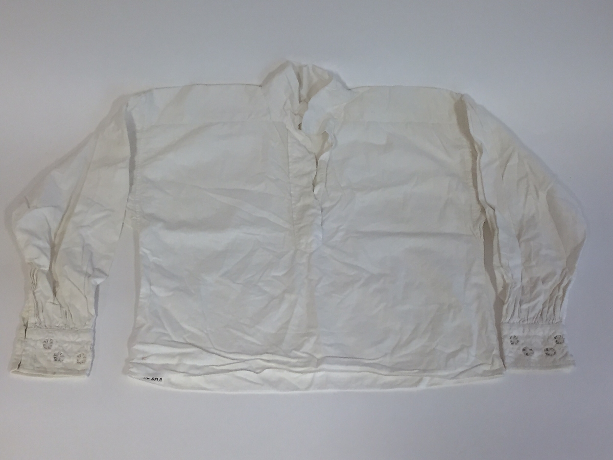 Lue, bryststykke/bringeduk og belte (C) til hardangerbunad, forkle (E) og skjorte (D) med hardangersømdetaljer.