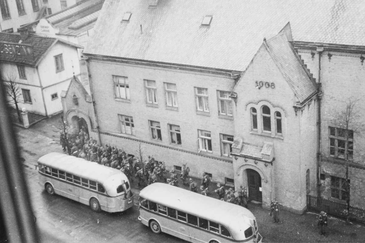Tyske tropper rykker inn på Majorstuen skole som skal brukes som kaserne. Bussene i forgrunnen var rekvirert  fra Oslo Sporveier til troppetransport.