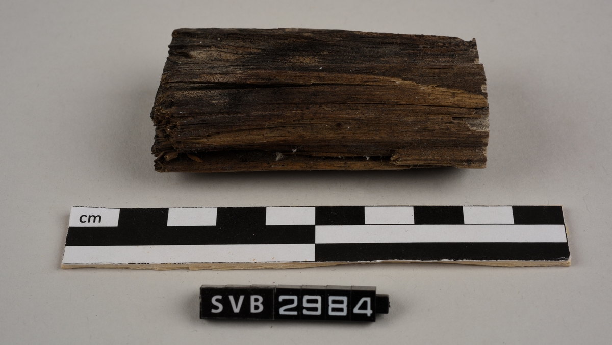 Tregjenstand med tilnærmet rundt tverrsnitt. Tremateriale er tørt og sprukkent. Det er 2 løse deler. Det er en lapp på undersiden med russiske tall og bokstaver.