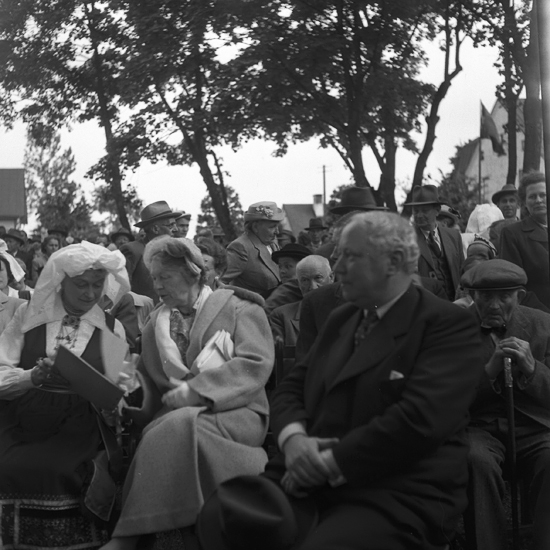 Foto av publiken, med en kvinna i folkdräkt (Värendsdräkt). Till höger landshövding Thorwald Bergquist.