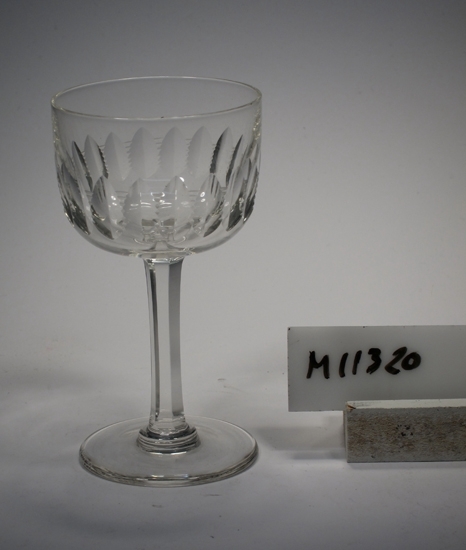 Brännvinsglas tillhörande servis "Ulle".
Möjligen tillverkat 1904.
Se "Ulle" slipben, nr. 1619-1629, pl. XXII i fotoalbum.
Slipad dekor i form av parallella skär med hack emellan.
Facetterat ben.
Ofärgat klarglas.
Ovan angivna mått avser övre diameter.
Fotdiameter: 50 mm.
Rymd: 6 cl.
Inskrivet i huvudkatalogen 1942.
Funktion: Brännvinsglas