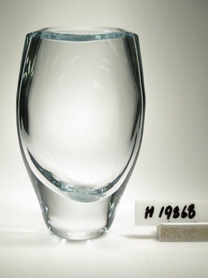 Blomglas B 867 formgiven av Gunnar Nylund 1961.
Tjockväggig vas i blåtonat glas.