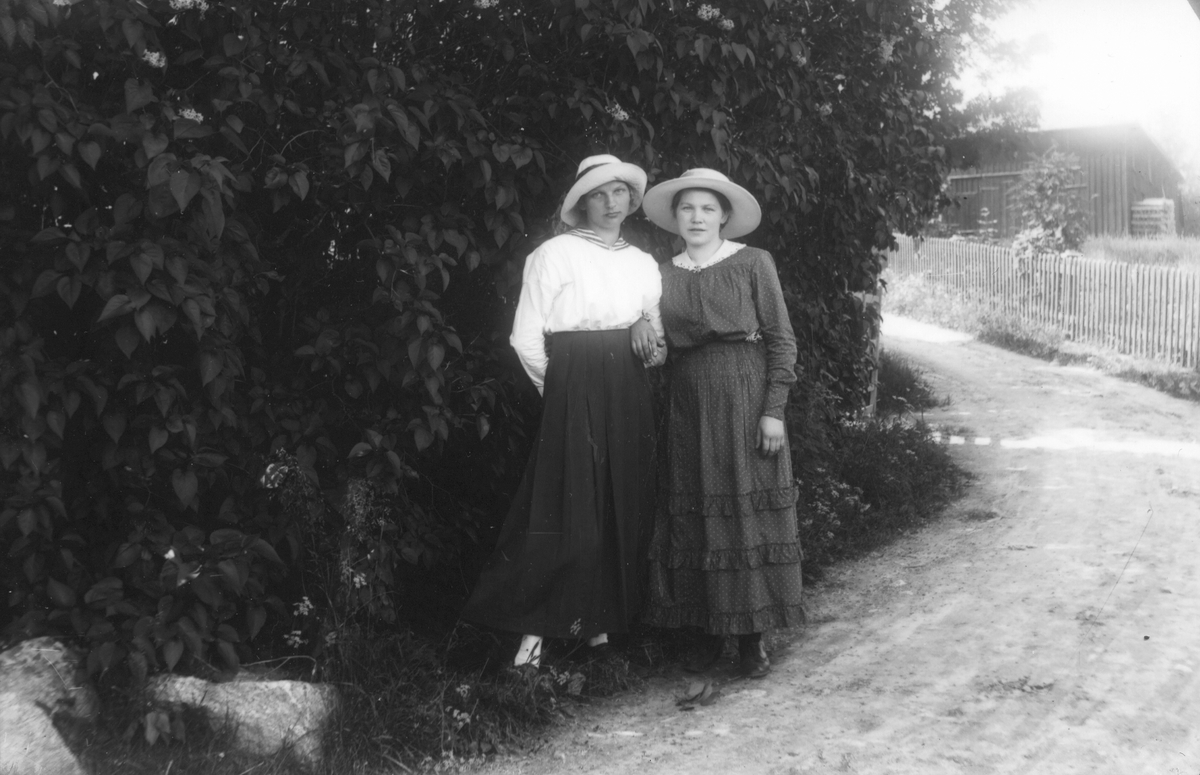 Två okända flickor. Bilden tagen utanför Halls, Lenninge 10:1, i bakgrunden syns uthuset hos Sundvalls.