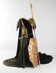 Costume Kirsten Flagstad in the role of Brünhilde in the Valkurie. This is the whole costume with gold waistcoat, green velvet skirt and cape. A belt with a prop knife around the waist. With the costume Kirsten also wore a gold helmet and a spear and shield in gold.