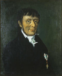 Portrett av Carl Stoltenberg. Mørk drakt, hvit skjorte og halsbind. Orden på venstre side av brystet.
