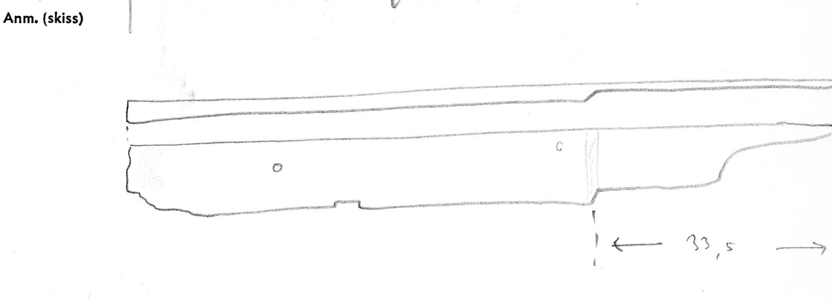 Bräda.
Ena långsidan mycket skadad. Avbrutna ändar. Tre genomgående spikhål.

Text in English: One beveled long edge. One end is tapered, which might have been for a reinforcing iron.
Two iron nail fastenings. One iron bolt or treenail with carved head.
Surface erosion and breakage.