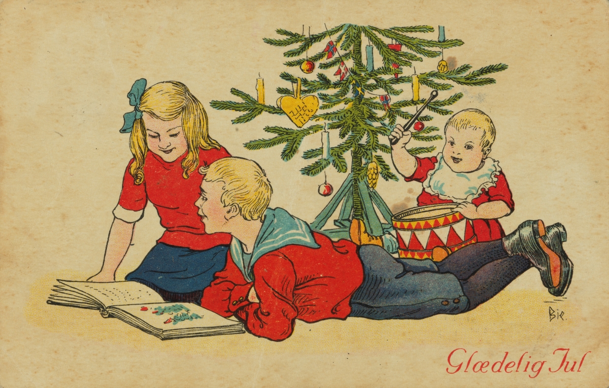 Julekort. Jule-og nyttårshilsen. Pike og gutt lerser i bok under juletreet. Barn som trommer.