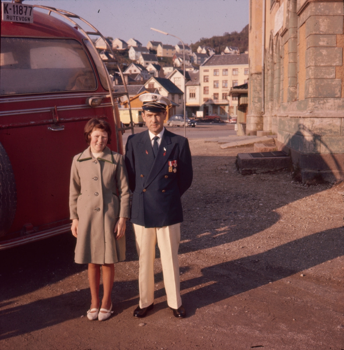 Far og datter ved en buss ved rutebilstasjonen i Egersund sentrum