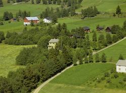 Kulturlandskap. Gulmalt bolighus med gårdsbruk bak. Dyrka ma