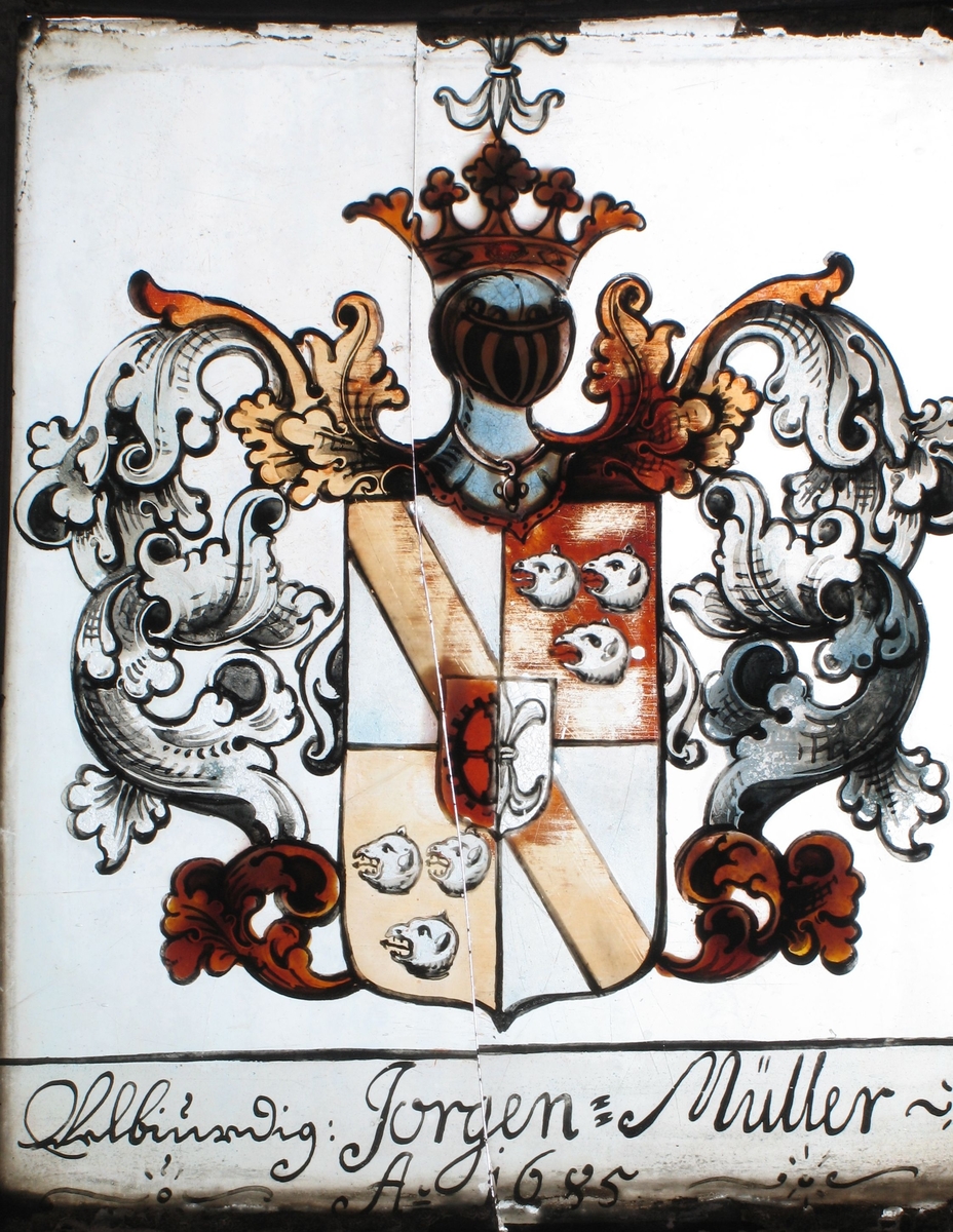 Våpenskjold i hvitt og rødbrunt, med ranke og kronet hjelm  i grått/blått og brunt. Tekst under: Jørgen:  Müller: Ao 1685.