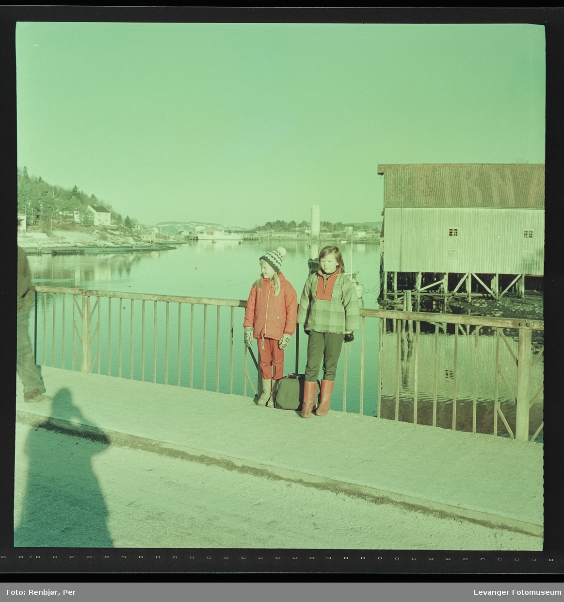Jenter på Sundbrua , med bryggene i bakgrunnen.