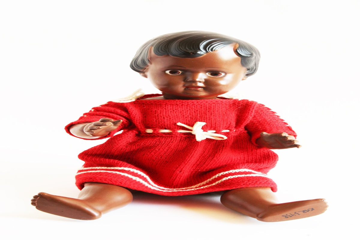 Siste eir: Gerd Berit Lie.

Dukken er mørkhudet med svart hår og brune øyne. Dukken ble vunnet på basar av moren til Gerd Berit, Elise, i ca 1960/61. Moren vant denne dukken samt en "baby-dokke" (KMR.3442).