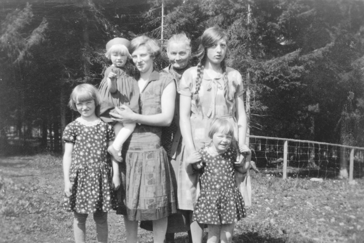 Voksne og barn i Rønningen, Helgøya. Fra venstre er Marit Rønningen f.1922, Else Margrethe Lindby f.1929,  Thora Lindby (1906-1972) , Tilla Rønningen f.1874, Mimi Rønningen f.1916. Foran er Tilla Rønningen (1923-1983).