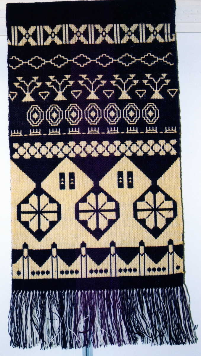 Veggåkle i dobbeltvev.
Mønsteret er inspirert av border fra tekstiler i Osebergskipet.

Tilstand: God.