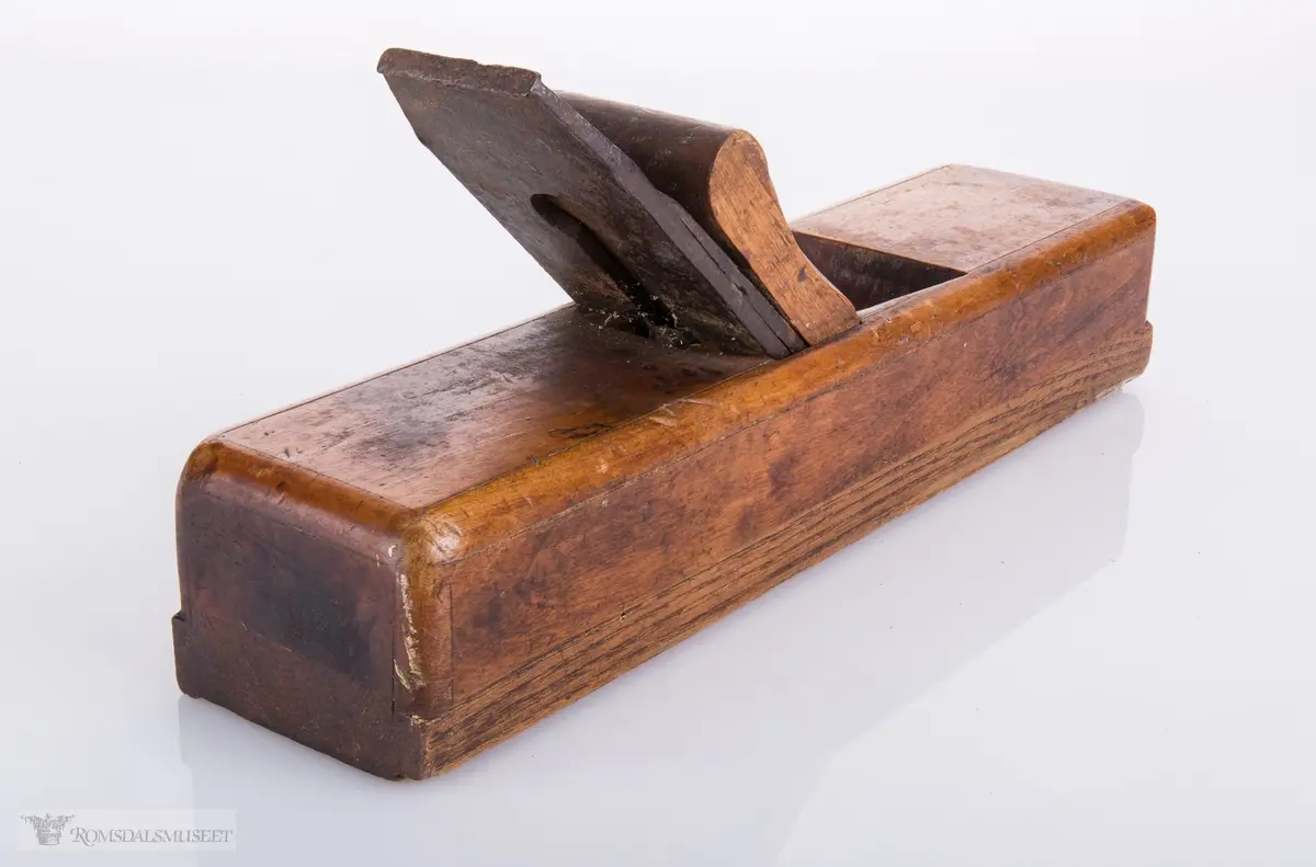 Rektangulær høvel med jern og kile. Har et spor på siden av sålen.
