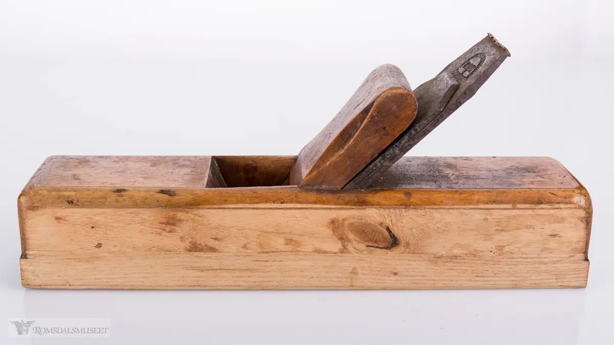 Rektangulær høvel med jern og kile. Har et spor på siden av sålen.