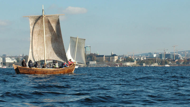 Trebåten Vaaghals på vannet med to seil, Oslo i bakgrunnen. Minst åtte personer ombord. (Foto/Photo)