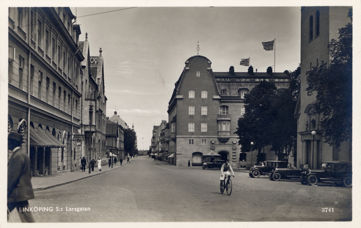 Orig. text: Linköping, S:t larsgatan.

S:t Larsgatan sedd norrut från korsningen med Storgatan. Närmast till vänster gamla Riksbankshuset, mitt i bild Sparbankshuset. Till höger skymtar S:t Larskyrkan.